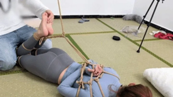 xy237 - barefoot yoga teacher tied up with ropes and playing with her bare feet.webp
