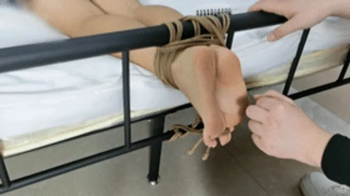 xy243-Chinese girl's bare feet are tied with ropes at the end of the bed to tickle her feet.webp