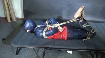 Myxxxy bound and gagged in shiny nylon Rainwear trying to free herself.webp