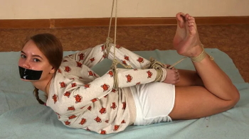 Gagged with a black duct tape barefoot Irene in long-sleeve and shorts, hogtied with hemp rope, wiggles on the floor (HD.webp
