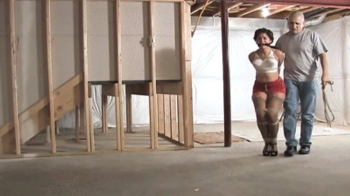 d2502SAHRYE-Curvy Latina left standing roped in her bra and girdle.webp
