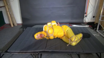 Ms Ungeniert bound and gagged in a shiny nylon Rainsuit trying to get free.webp