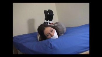 Reinforced industrial strength mouth packed gag and tight hogtie for 24 year old wearing leather boots.webp