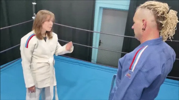 Girl in white gi vs guy in blue gi.webp