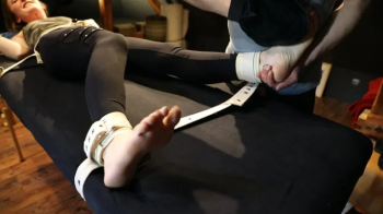 Kovaluna gets tickled on the strap table.webp