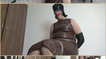 Mistress in brown leather dress tied up to a chair.webp