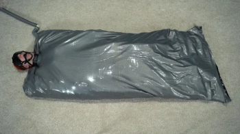 Gray vacuum bed with mask balls and gag.webp