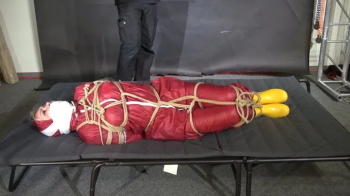 Alice tied and gagged in shiny nylon Raingear.webp