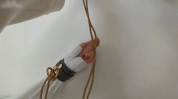 xy325-Petite cute Chinese girl is tied up with ropes in an iron ring on the wall.webp