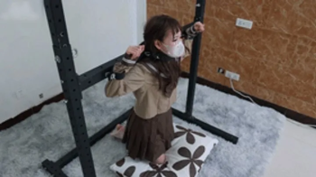 xy326-A petite girl in white stockings is restrained by a metal bracket.webp