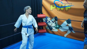 Asian girl in a gi wrestles a guy.webp