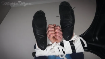 Madalynn is chair tied in rope bondage with her leather ballet slippers on display WMV.webp