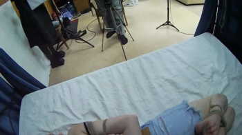 Barefoot Amy in black bra and jeans shorts, hogtied with hemp rope, is tickled and teased by Blackshark - view from her.webp