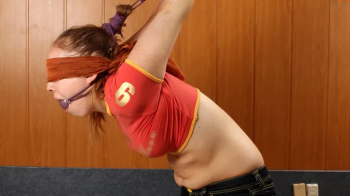 Bound-feet Clip Store - Barefoot Sharon in red top and black shorts, tied in the strappado kneeling.webp