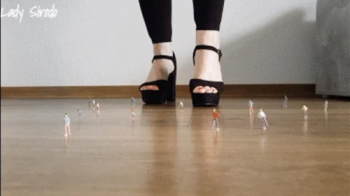 Lady Sirodo - Crushing mini model railroad figures with black sandals.webp